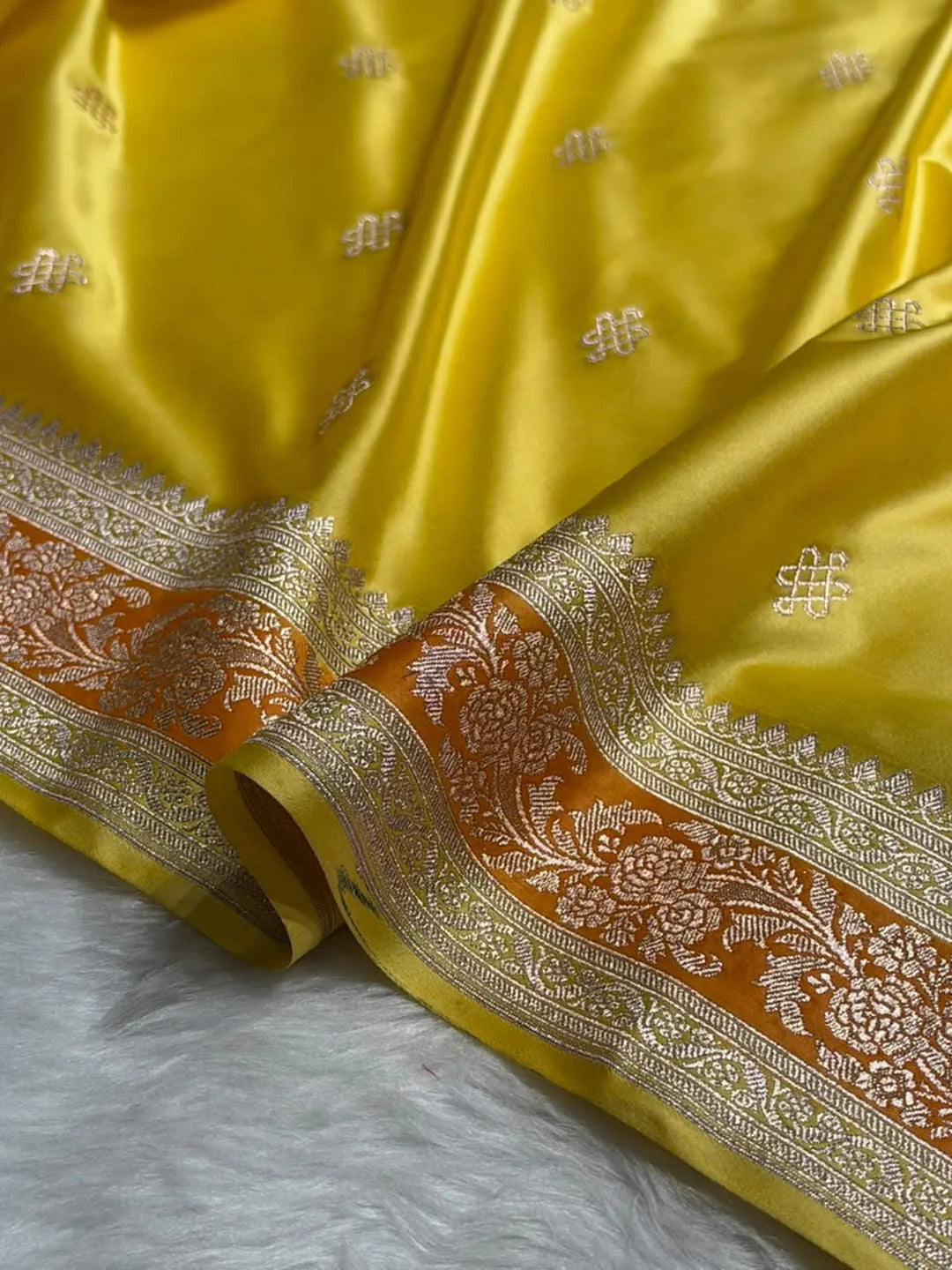 Yellow Mashru silk Banarasi saree with floral booti motifs and contrasting orange-toned floral border - Katan Banaras