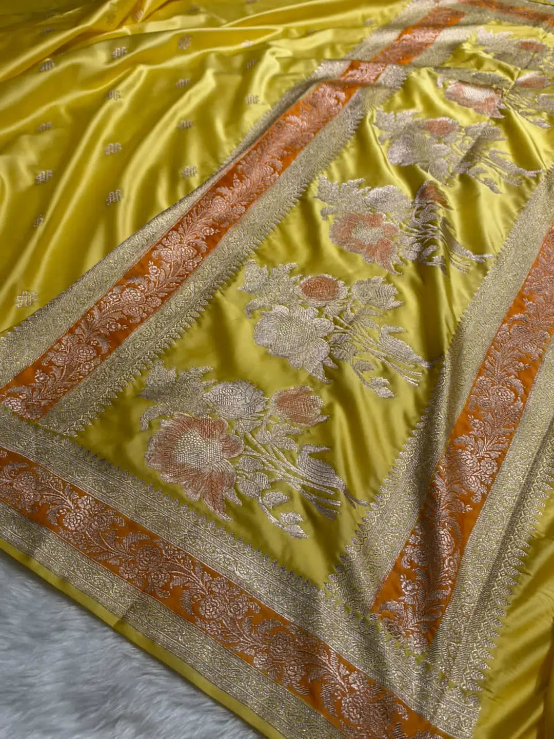 Yellow Mashru silk Banarasi saree with floral booti motifs and contrasting orange-toned floral border - Katan Banaras